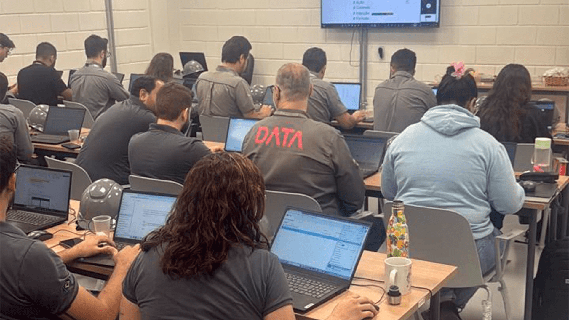 Equipe da Data Engenharia participando de treinamento prático com notebooks.